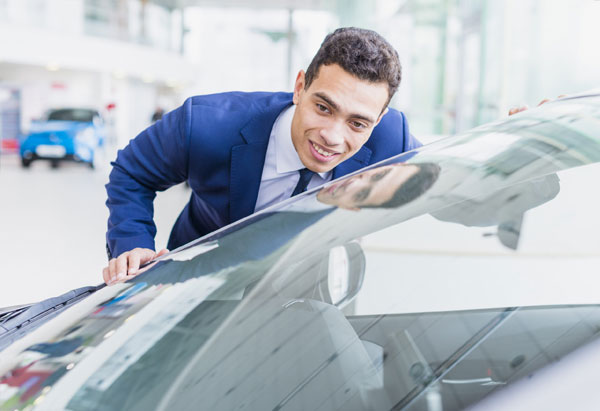 Technician inspecting a cracked windshield before windshield replacement in Richardson