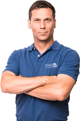 A man in a blue polo shirt with the logo Windshield Hub crosses his arms and looks confidently forward. His short hair is neatly styled, and the background is transparent